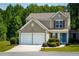 Charming two-story home featuring a two-car garage, landscaped front yard, and a welcoming blue front door at 271 Balaban Cir, Woodstock, GA 30188