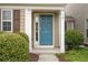 Close-up of the stylish blue front door with decorative sidelights and lush landscaping at 271 Balaban Cir, Woodstock, GA 30188