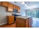 Well-lit kitchen features wood cabinets, stainless steel microwave, kitchen island and access to sliding glass doors at 271 Balaban Cir, Woodstock, GA 30188