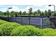 View of well-maintained tennis court surrounded by lush landscaping and fencing in a private community setting at 271 Balaban Cir, Woodstock, GA 30188