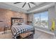 Stylish bedroom with exposed brick wall, modern decor, and cityscape view from the window at 285 Centennial Olympic Park Dr # 1705, Atlanta, GA 30313