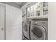 Modern laundry room with front loading washer and dryer plus ample storage shelves for supplies at 285 Centennial Olympic Park Dr # 1705, Atlanta, GA 30313