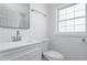 A well-lit bathroom with a white vanity, a sleek mirror, and an updated toilet at 2215 Gordon Se Cir, Smyrna, GA 30080