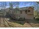 Backyard view of a multi-level deck and exterior of the home, surrounded by trees at 4142 Huntcliff Dr, Woodstock, GA 30189