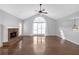 Bright living room with hardwood floors, a brick fireplace, and a large arched window at 4142 Huntcliff Dr, Woodstock, GA 30189