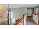 Upstairs hallway featuring wood railing and a view of a stone accent wall and windows at 1536 Granby Ln, Locust Grove, GA 30248