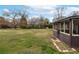 Extensive backyard featuring lush green grass, mature trees, and sunroom access at 3811 Lavilla Dr, Powder Springs, GA 30127