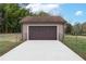 Detached garage features concrete driveway and brown door at 3811 Lavilla Dr, Powder Springs, GA 30127