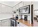 Kitchen features stainless steel oven, microwave, light wood countertop space, and view into the living room at 3811 Lavilla Dr, Powder Springs, GA 30127