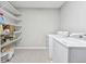 Laundry room featuring a washer, dryer, and wire shelving for ample storage at 3811 Lavilla Dr, Powder Springs, GA 30127