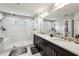 Bright bathroom featuring double sinks with a glass-enclosed shower and marble tile at 4125 Barry Pl, Chamblee, GA 30341