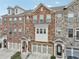 Three-story townhome with a brick and stone facade, and attached garages at 4125 Barry Pl, Chamblee, GA 30341