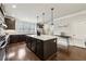 Beautiful kitchen with a large island, dark wood cabinets, quartz countertops, stainless appliances, and modern pendant lighting at 4125 Barry Pl, Chamblee, GA 30341