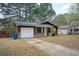 Exterior view of a rustic home featuring a driveway and well-maintained yard at 6347 Steepleridge Ct, Riverdale, GA 30296