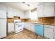 Compact kitchen with white appliances, cabinets, and vinyl floors at 6347 Steepleridge Ct, Riverdale, GA 30296