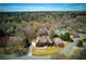 A high angle, full shot, aerial view of a well-kept home with green lawn and a manicured yard at 8005 Sweet Creek Rd, Johns Creek, GA 30097