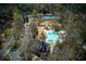 Aerial view of community amenities featuring a pool, playground, and tennis courts, surrounded by trees at 8005 Sweet Creek Rd, Johns Creek, GA 30097