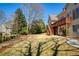 View of the backyard and deck with stairs, surrounded by mature trees and landscaping at 8005 Sweet Creek Rd, Johns Creek, GA 30097