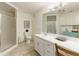 Clean bathroom with a white vanity, framed mirror, tiled shower, and ample cabinet storage at 8005 Sweet Creek Rd, Johns Creek, GA 30097