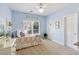 Bright bedroom featuring soft blue walls, carpeted floors, and a large window, offering comfort and style at 8005 Sweet Creek Rd, Johns Creek, GA 30097