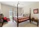 Cozy bedroom with four-poster bed, plush carpet, and a view of a nature, offering comfort and style at 8005 Sweet Creek Rd, Johns Creek, GA 30097