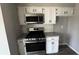 Well-lit kitchen with white cabinets and modern stainless steel appliances at 309 Peachtree Dr, Riverdale, GA 30274