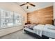 Inviting bedroom featuring wood accent wall and a ceiling fan at 636 Georgia Way, Woodstock, GA 30188