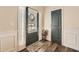 Welcoming entryway with hardwood floors, paneled walls, and a decorative front door with sidelights at 636 Georgia Way, Woodstock, GA 30188