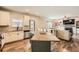 Open kitchen with white cabinets, granite countertops, and hardwood floors, open to the living room at 636 Georgia Way, Woodstock, GA 30188