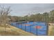 Outdoor pickleball courts with a blue and red surface and surrounded by trees, offering a space for community recreation at 636 Georgia Way, Woodstock, GA 30188