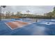 Community tennis courts featuring blue and red surfaces, nets, and lights, perfect for daytime or evening play at 636 Georgia Way, Woodstock, GA 30188
