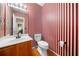Small powder room featuring striped wallpaper and a toilet next to the sink at 924 Evian Nw Dr, Kennesaw, GA 30152