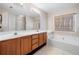 Bright bathroom features a double vanity and a large tub next to a window at 924 Evian Nw Dr, Kennesaw, GA 30152