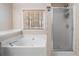 Bright bathroom features a large tub next to a window, and a shower at 924 Evian Nw Dr, Kennesaw, GA 30152