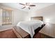 Cozy bedroom featuring a queen-sized bed, ceiling fan, and a window at 924 Evian Nw Dr, Kennesaw, GA 30152