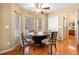 Bright breakfast nook featuring a round wood table, four upholstered chairs and three windows with wood blinds at 924 Evian Nw Dr, Kennesaw, GA 30152