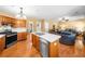 Open concept kitchen with wooden cabinets, stainless appliances and a kitchen island that flows into the living room at 924 Evian Nw Dr, Kennesaw, GA 30152