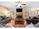 Spacious living room featuring a fireplace, large TV, hardwood floors, ceiling fan and natural light at 924 Evian Nw Dr, Kennesaw, GA 30152