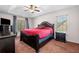 Main bedroom featuring a tray ceiling, a large bed, bedside tables, dresser, and two large windows at 924 Evian Nw Dr, Kennesaw, GA 30152