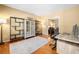 Home office features wood floors, neutral walls, modern wood desk, bookshelves, and adjacent living area at 924 Evian Nw Dr, Kennesaw, GA 30152