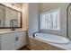 A bright bathroom with a soaking tub next to a window and a glass-enclosed shower at 167 Pinewood Dr, Covington, GA 30014