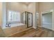A bathroom featuring a soaking tub with a view and a glass-enclosed shower at 167 Pinewood Dr, Covington, GA 30014