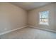 This bedroom features neutral carpeting and a window that provides natural light at 167 Pinewood Dr, Covington, GA 30014