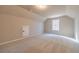 A large bonus room with neutral walls, carpeted floors, and a window providing natural light at 167 Pinewood Dr, Covington, GA 30014