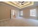 Main bedroom with tray ceilings, neutral carpet, and double doors that lead to the main bathroom at 167 Pinewood Dr, Covington, GA 30014