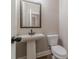Cozy powder room featuring a pedestal sink, framed mirror, and a white toilet at 167 Pinewood Dr, Covington, GA 30014