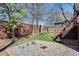 Landscaped backyard featuring a gravel area with a fire pit, wooden fence, and stairs to a deck at 280 Josephine St, Atlanta, GA 30307