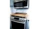 Stainless steel stove with wooden serving tray and a marble backsplash at 510 Coventry Rd # 8A, Decatur, GA 30030