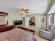 A bedroom with a large window and a cozy chair, illuminated by a modern ceiling fan at 5221 La Paloma Sw Dr, Lilburn, GA 30047