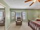 Cozy bedroom featuring a chair by a large window, complemented by a ceiling fan at 5221 La Paloma Sw Dr, Lilburn, GA 30047